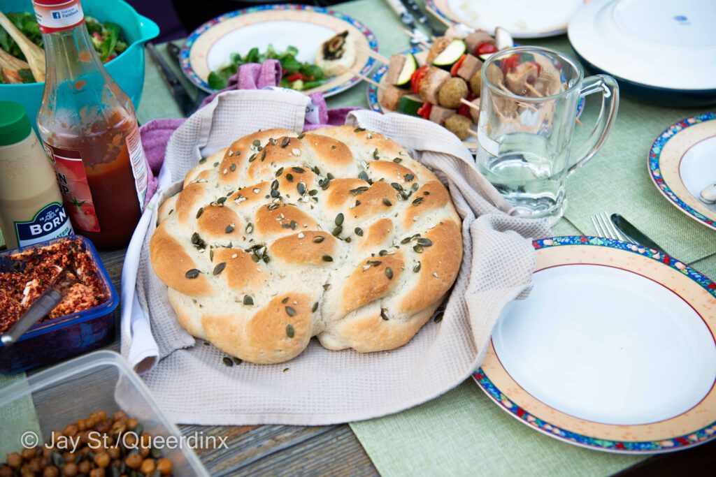 Das Challah-Brot in seiner Endform, dahinter Gemüsespieße, daneben Tomatenbutter. Was eben alles zu einem guten veganen Sommergrill dazugehört.