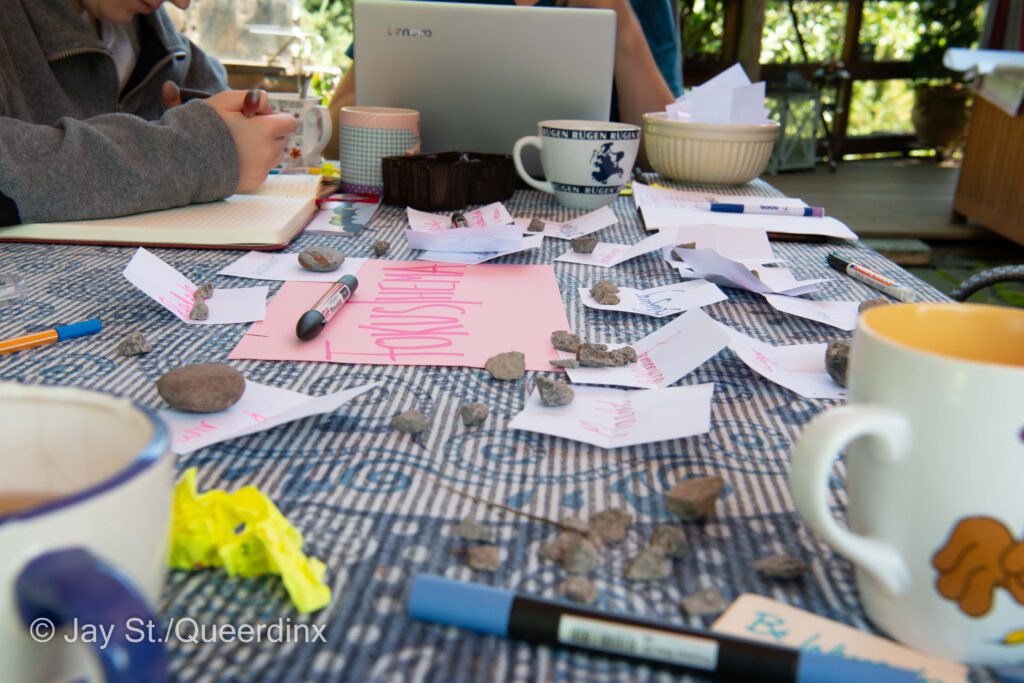 Auf einem Tisch liegt in der Mitte ein Zettel auf dem "Fokusthema" steht - drumherum liegen weitere kleine Zettel mit Vorschlägen für Themen. 